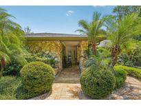 Charming front entrance with stone facade, landscaping, and a brick walkway at 98 Wisteria Dr, Longwood, FL 32779