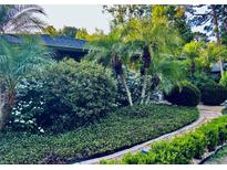 Beautiful landscaping featuring lush greenery and palm trees enhances the curb appeal of this home at 98 Wisteria Dr, Longwood, FL 32779