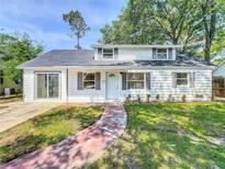 Charming home featuring a well-manicured lawn, gray shutters, and a welcoming front entrance at 1082 Hamilton Ave, Longwood, FL 32750