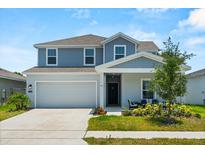 Charming two-story home with a well-maintained lawn and a two-car garage on a sunny day at 1209 Deepwater Cir, Eagle Lake, FL 33839