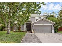 Charming two-story home with a gray exterior, well-manicured lawn, and a two-car garage at 1245 Reagans Reserve Blvd, Apopka, FL 32712