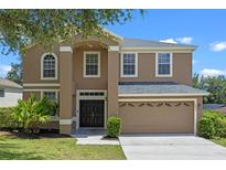 Charming two-story home with neutral paint, landscaped yard, and two car garage at 12824 Cloverdale Ln, Clermont, FL 34711