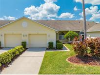 Charming single-story home with attached garages, manicured landscaping, and a well-maintained lawn at 130 Club Villas Ln, Kissimmee, FL 34744