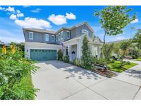 Charming two-story home with a well-manicured lawn, teal garage door, and welcoming front porch at 13822 Darchance Rd, Windermere, FL 34786