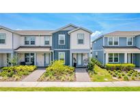 Charming townhouse with blue and white exterior and landscaped front yard on a sunny day at 14250 Sapelo Beach Dr, Orlando, FL 32827
