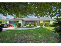 Charming single-story home featuring manicured lawn and lush landscaping at 1460 Spring Ridge Cir, Winter Garden, FL 34787