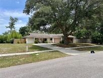 Charming single-story home with a well-manicured lawn and mature shade tree at 1525 Jaguar Cir, Apopka, FL 32712