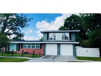 Charming two-story home featuring a brick and gray facade with a two-car garage and well-manicured lawn at 1919 E South St, Orlando, FL 32801