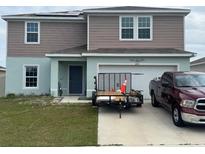 Charming two-story home featuring a spacious front yard and attached garage at 268 Fiddlewood Ct, Davenport, FL 33837