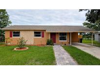 Charming single-story home featuring a well-manicured lawn and a brick pathway leading to the front door at 331 Greens End St, Orlando, FL 32810