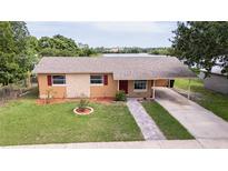 Charming single-story home featuring a well-manicured lawn, complemented by a brick walkway and a convenient carport at 331 Greens End St, Orlando, FL 32810