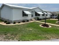 Charming single-story home with well-maintained lawn, awnings, and tasteful landscaping at 361 Dreama Dr, Davenport, FL 33897