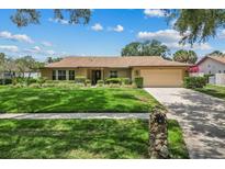 Charming single-story home featuring a well-manicured lawn and traditional landscaping at 3942 Orange Lake Dr, Orlando, FL 32817