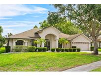 Charming home featuring a well-manicured lawn, mature trees, and attractive landscaping at 4905 Emilee Grace Ln, St Cloud, FL 34771
