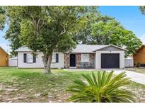 Charming single-story home features a stone-accented entrance and a lush, green lawn at 558 Tyler Ave, Deltona, FL 32725