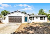 Charming single-story home featuring a two-car garage, a blue front door and a well-maintained front yard at 1859 Matterhorn Dr, Orlando, FL 32818