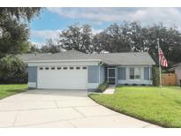 Charming single-story home featuring a well-manicured lawn, attached two-car garage, and inviting entrance at 1077 Dees Dr, Oviedo, FL 32765