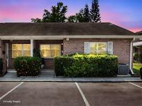 Charming brick condo featuring a well-maintained lawn and assigned parking spaces at 1230 Americana Pl, Orlando, FL 32807