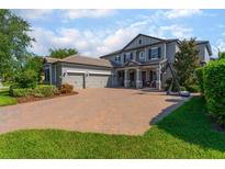 Beautiful two-story home boasts a paver driveway, three-car garage, and well-manicured landscaping at 14357 United Colonies Dr, Winter Garden, FL 34787