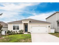 Charming one-story home featuring a well-manicured lawn, two-car garage, and a welcoming front door at 1791 Hackberry St, Clermont, FL 34715