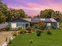 Charming single-story home featuring a well-manicured lawn and solar panels for energy efficiency at 1872 Wayside Dr, Orlando, FL 32818