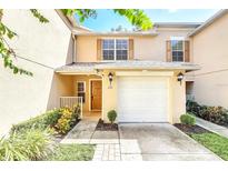 Charming two-story townhome featuring a one car garage and a welcoming front entrance with manicured landscaping at 221 Sterling Springs Ln, Altamonte Springs, FL 32714
