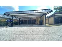 Carport area of a residential property, featuring parking and adjacent residential building exteriors at 2235 Silver Pines Pl # 401, Orlando, FL 32808