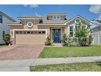 Charming home with a brick driveway, two car garage, and well manicured lawn at 2598 Trielle Ave, Kissimmee, FL 34741