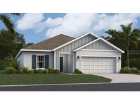 Charming one-story home featuring a well-maintained lawn, two car garage, and light gray stucco exterior at 415 Puma Loop, Groveland, FL 34736