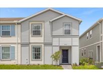 Charming two-story townhome featuring gray siding, well-manicured lawn, and inviting entryway at 4310 Lana Ave, Davenport, FL 33897