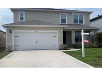 Charming two-story home featuring a two-car garage, well-maintained landscaping, and a 'For Sale' sign at 5350 Pine Lilly Dr, St Cloud, FL 34771