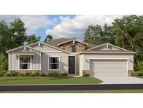 Beautiful one-story home with stone accents, a well-manicured lawn, and an attached two-car garage at 773 Tundra Loop, Groveland, FL 34736