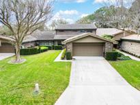 Charming brick home with a well-manicured lawn, mature trees, and a two-car garage at 103 Odin Dr, Winter Haven, FL 33884