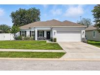 Charming single-story home with a well-manicured lawn and two car garage at 15411 Taurus Ct, Mascotte, FL 34753