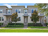 Charming gray and white townhome featuring a manicured lawn and inviting front entrance at 15946 Marina Bay Dr, Winter Garden, FL 34787