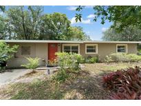 Charming single-story home with a red front door and mature landscaping in the front yard at 17 S Aurora Dr, Apopka, FL 32703