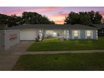 Charming single-story home with a well-manicured lawn and inviting facade at sunset at 217 Spencer St, Orlando, FL 32839