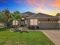 Charming single-story home featuring a well-manicured lawn, tropical landscaping, and a paved driveway at 2528 Double Tree Pl, Oviedo, FL 32766