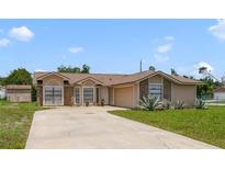 Traditional single-story home with brick accents, attached garage, and a large driveway at 2880 Trenton Ln, Deltona, FL 32738