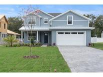 Charming two-story home showcasing a well-manicured lawn and a paved driveway leading to a two-car garage at 3022 Peel Ave, Orlando, FL 32806