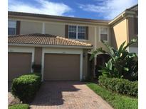Charming townhome with a red tile roof, attached garage, and inviting landscaping in a well-maintained community at 6360 Ranelagh Dr # 104, Orlando, FL 32835
