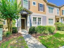 Inviting townhouse featuring a covered entryway, manicured landscaping, and a welcoming facade at 7508 Bentonshire Ave, Windermere, FL 34786
