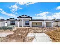 New construction featuring a white exterior, black roof, and open three car garage at 9241 Eagles Perch Pl, Orlando, FL 32825