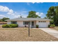 Charming single-story home with a well-manicured lawn, lovely shrubbery, and an attached one-car garage at 1198 E Hancock Dr, Deltona, FL 32725