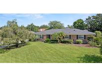Charming brick home featuring a well-manicured lawn and mature landscaping at 1271 Old Mill Rd, Orlando, FL 32806