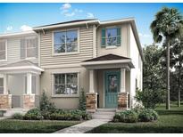 Charming two-story home featuring a quaint porch, stone accents, manicured landscaping, and a refreshing teal front door at 1315 Tarflower Dr, Winter Springs, FL 32708