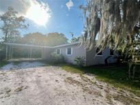 Charming single-story home with a carport and a gravel driveway, offering a blend of comfort and convenience at 212 Homewood Dr, Sanford, FL 32773