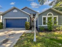 Charming single-story home with a blue garage door and well-manicured landscaping on a sunny day at 612 Doe Cove Pl, Apopka, FL 32703