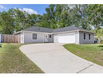Charming single-story home with a well-manicured lawn and a curved driveway leading to an attached two-car garage at 6245 Sleepy Hollow Dr, Orlando, FL 32810