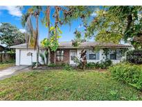 Charming single story home with brick accents, mature landscaping, and white painted garage at 7024 Harwick Dr, Orlando, FL 32818